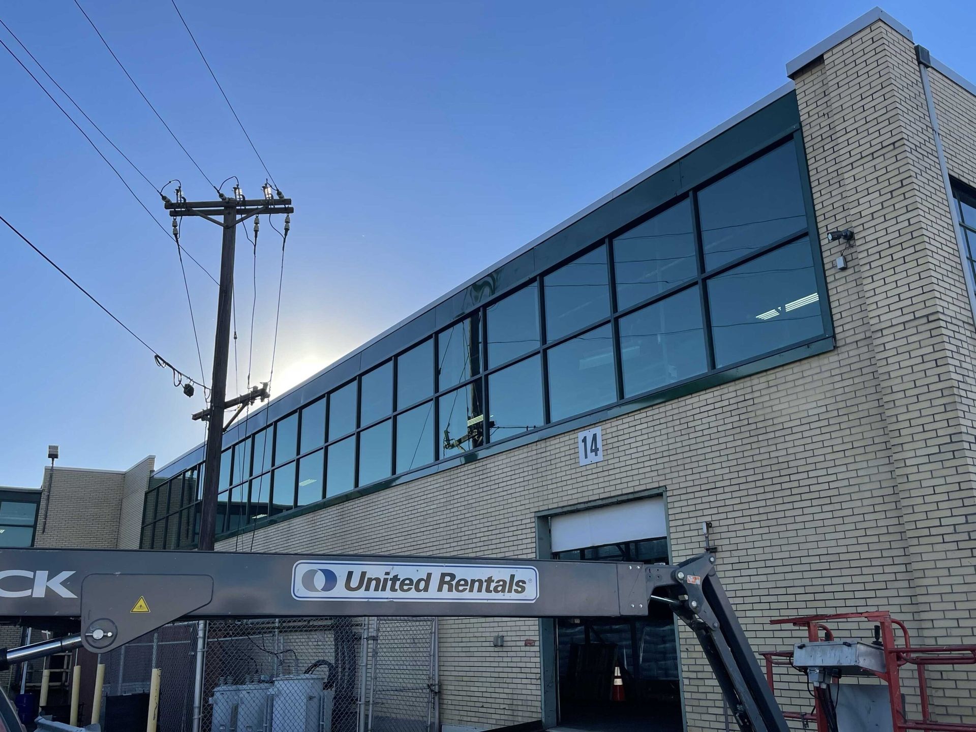 A large brick building with a lot of windows and a lift in front of it.