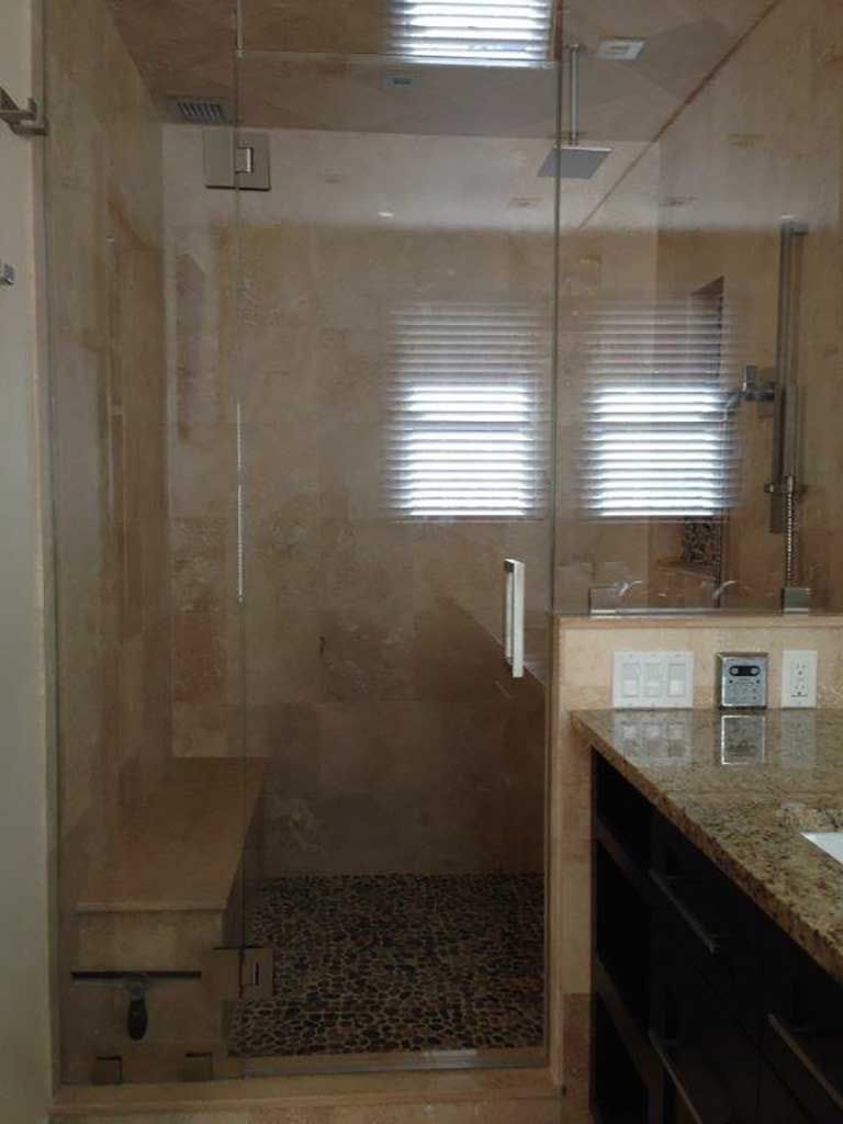 A bathroom with a walk in shower and a sink.