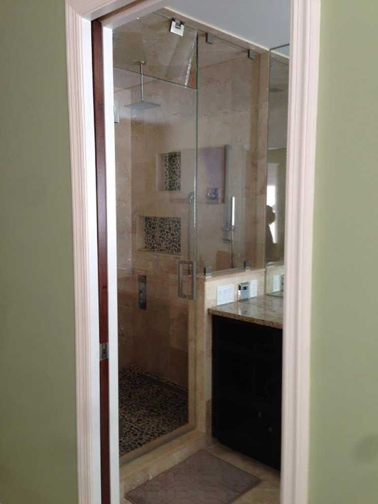 A bathroom with a walk in shower and a sink.