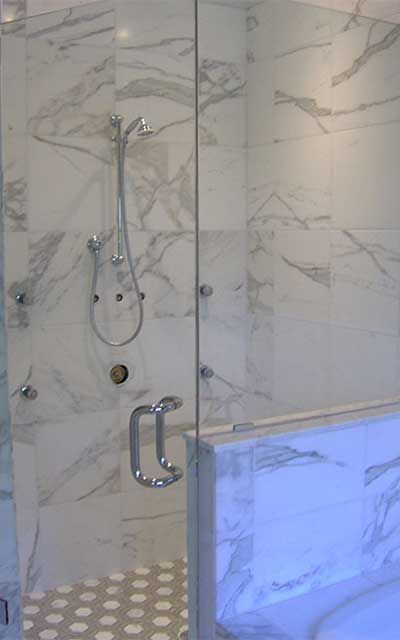 A bathroom with a bathtub and a shower with a glass door.