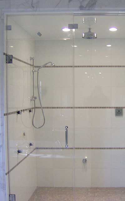 A shower with a glass door and a shower head.