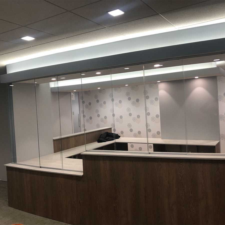 An empty office with a glass wall and a wooden counter.