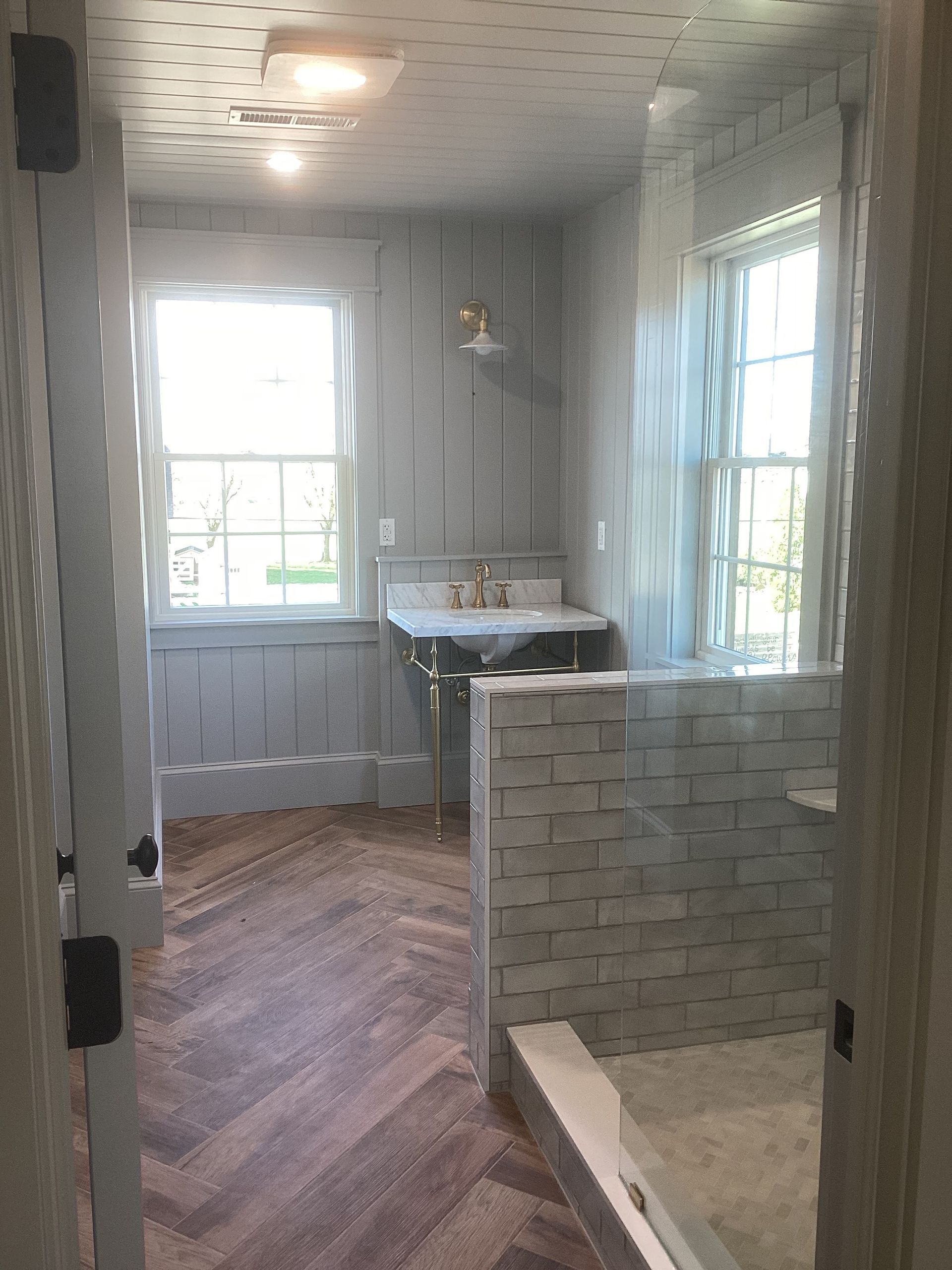 A bathroom with a sink and a walk in shower.
