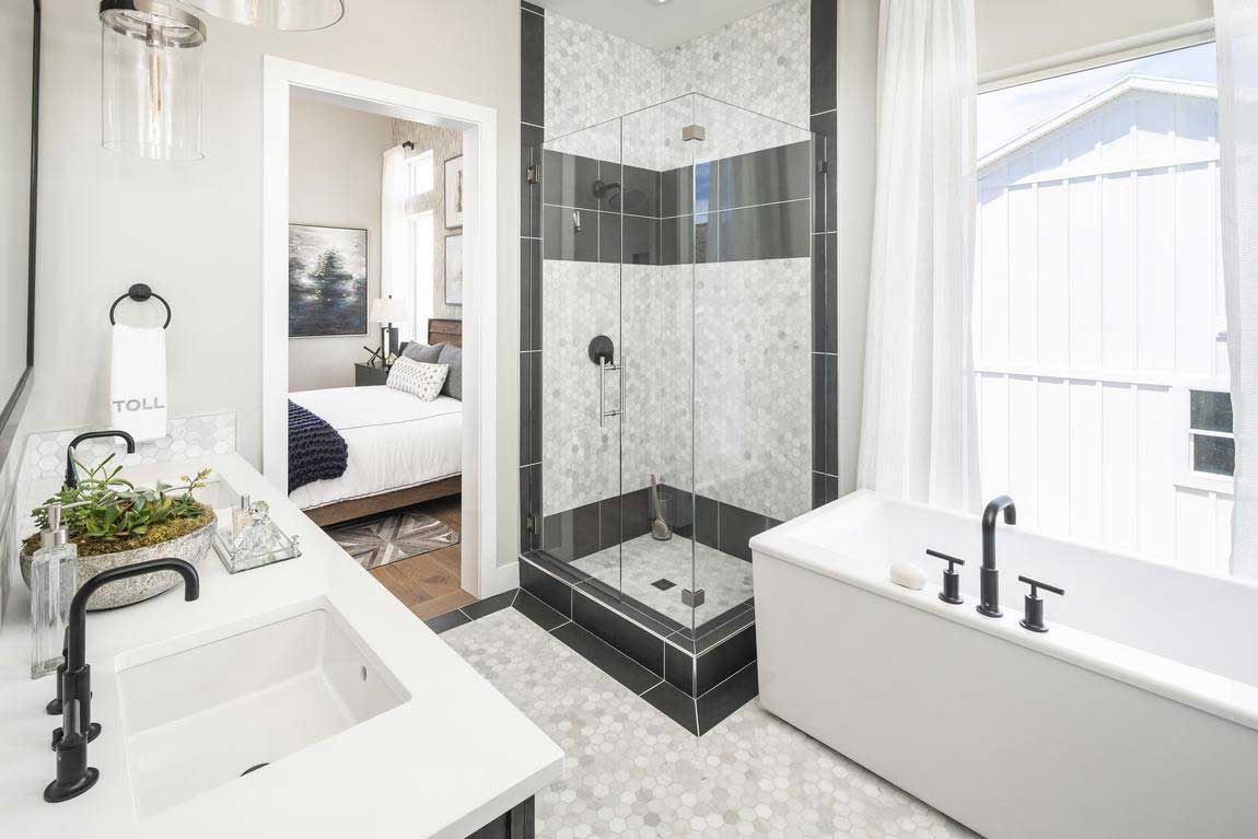 A bathroom with a walk in shower , tub , sink and mirror.