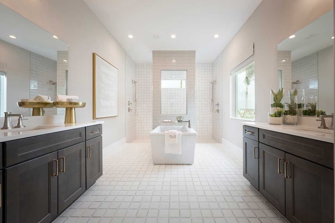 A large bathroom with two sinks , a tub , and two mirrors.