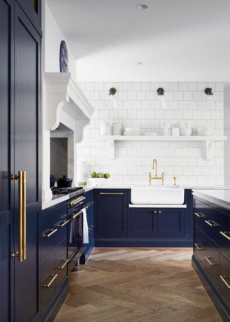 A kitchen with blue cabinets and a white sink.