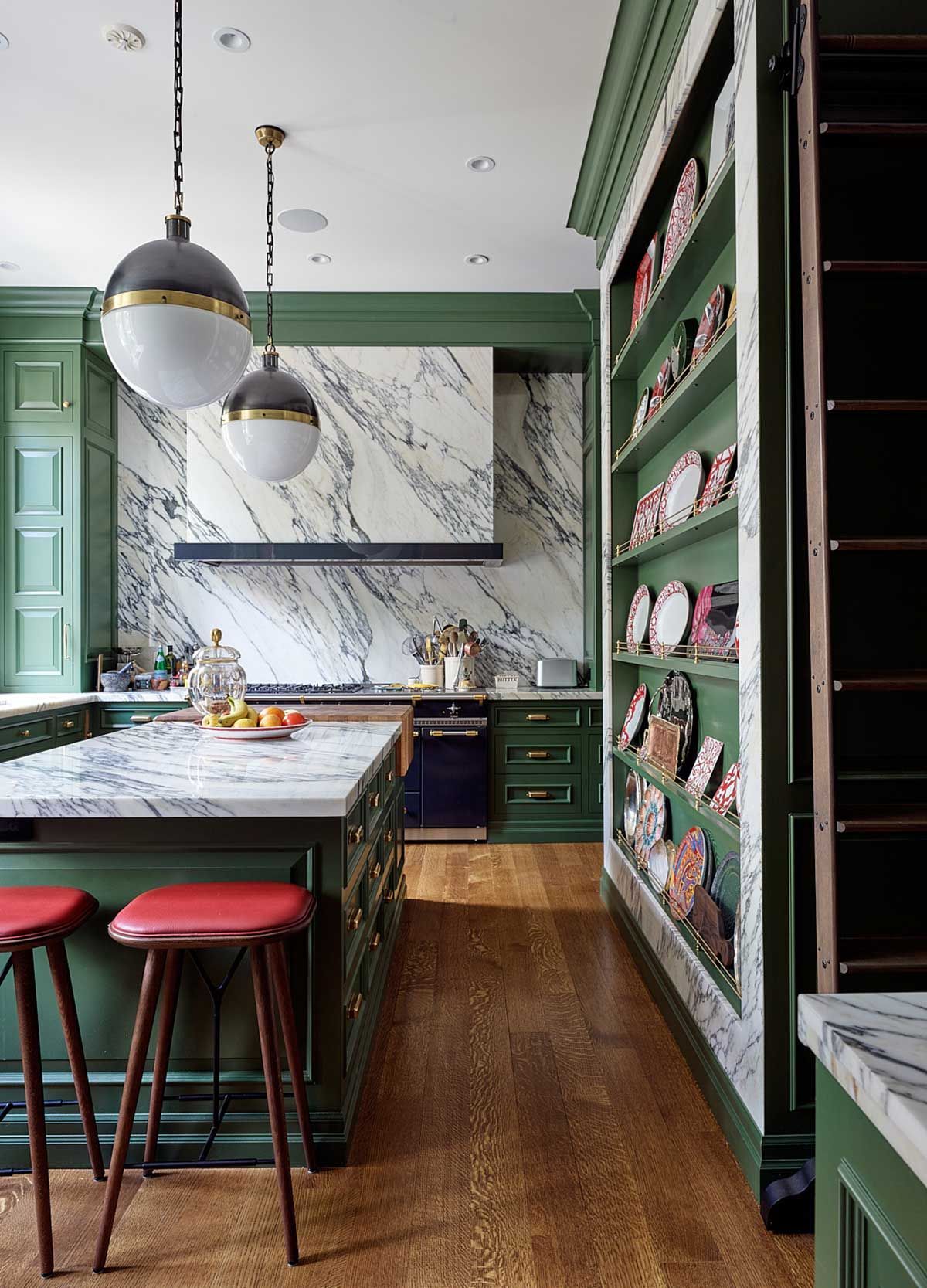 A kitchen with green cabinets and marble counter tops