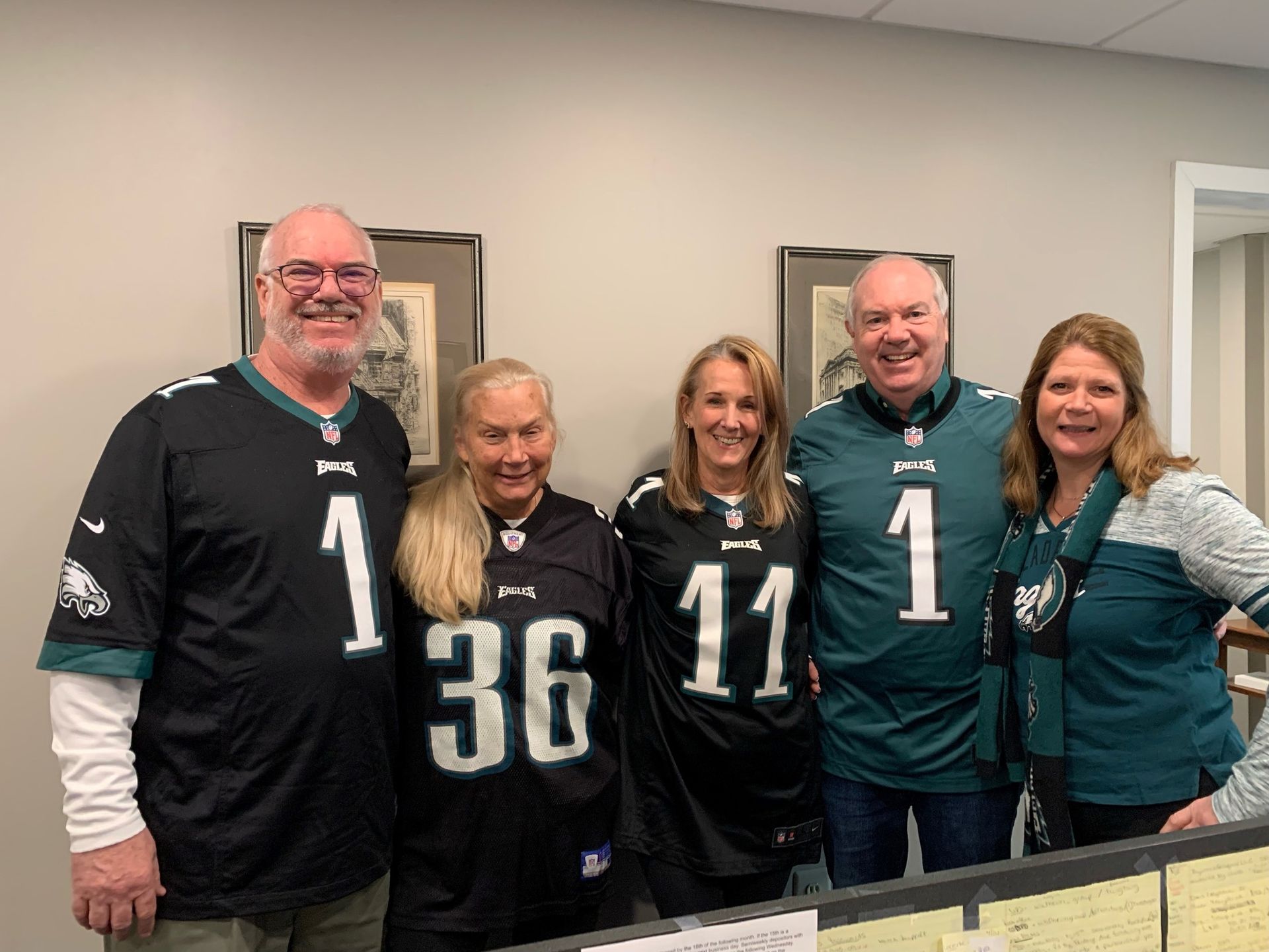 A group of people wearing eagles jerseys are posing for a picture.