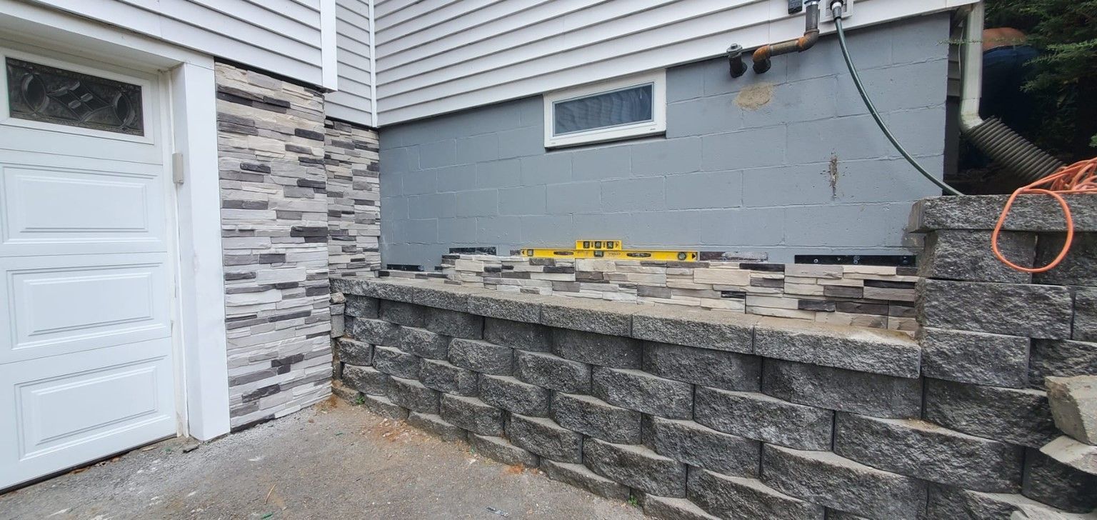 A brick wall is being built next to a garage door.