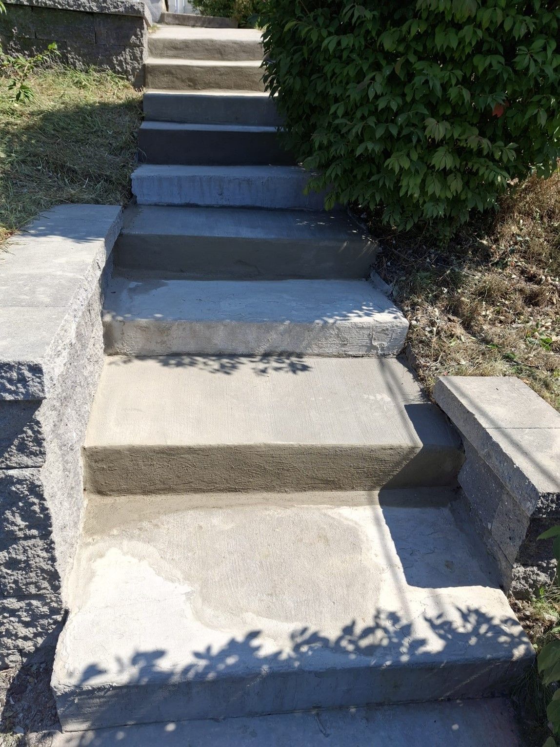 A set of concrete stairs leading up to a house.