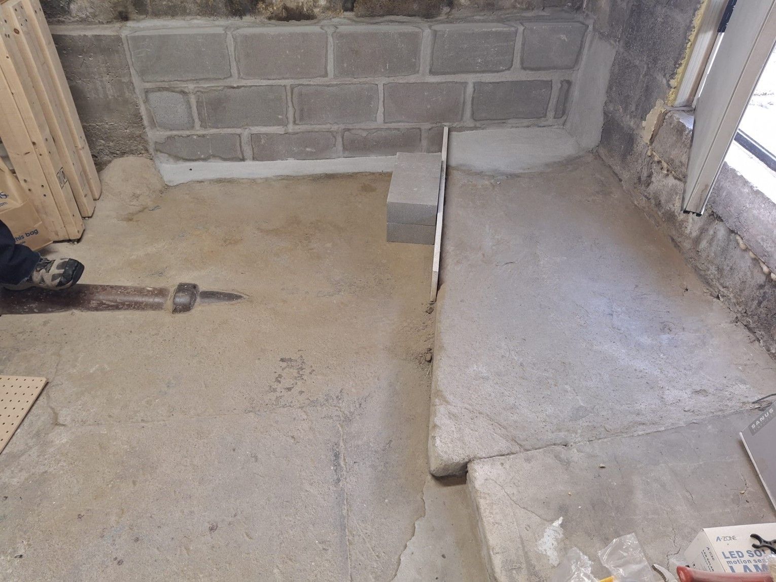 A person standing on a concrete floor next to a brick wall