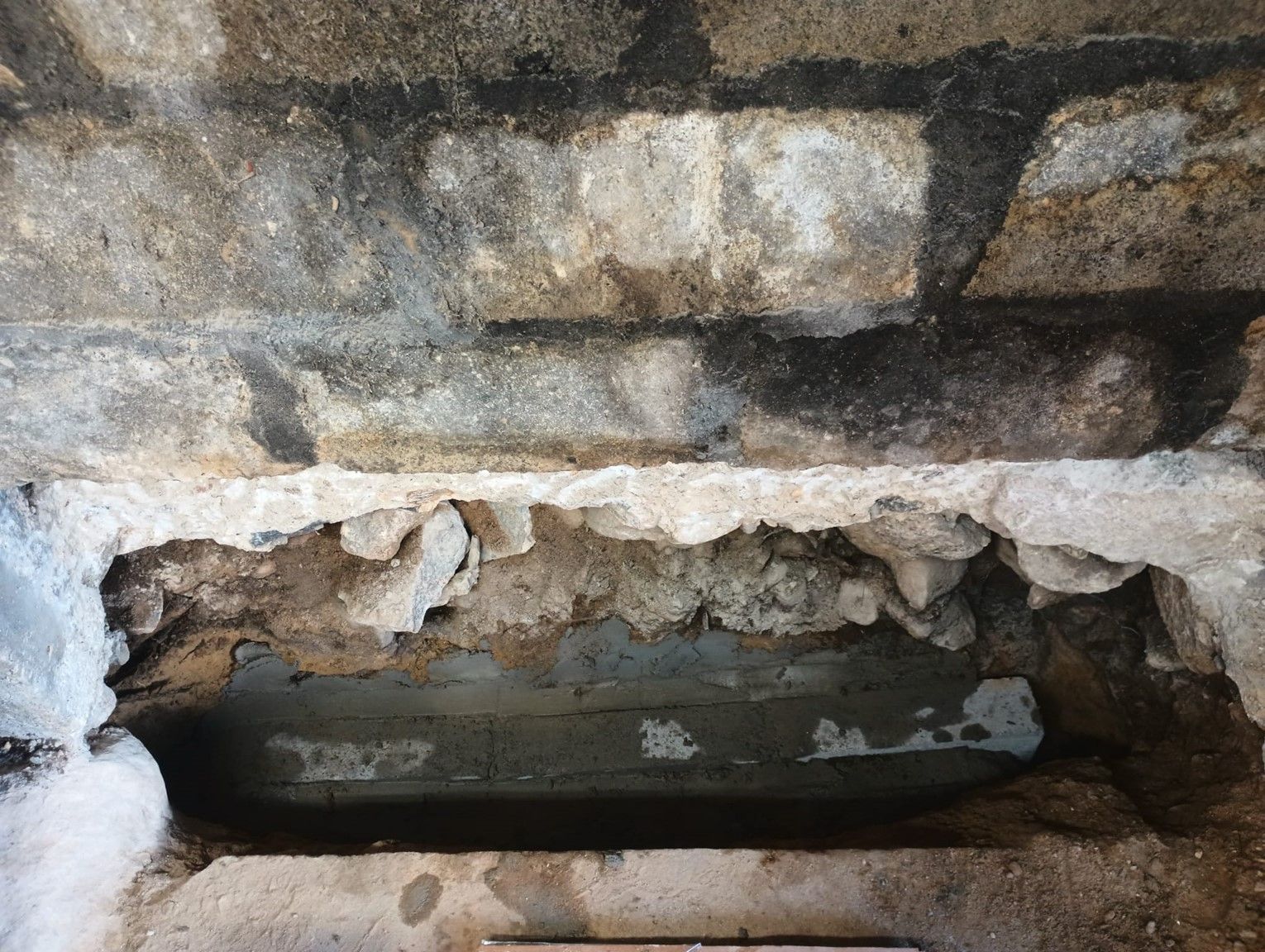A brick wall with a concrete block in the middle of it