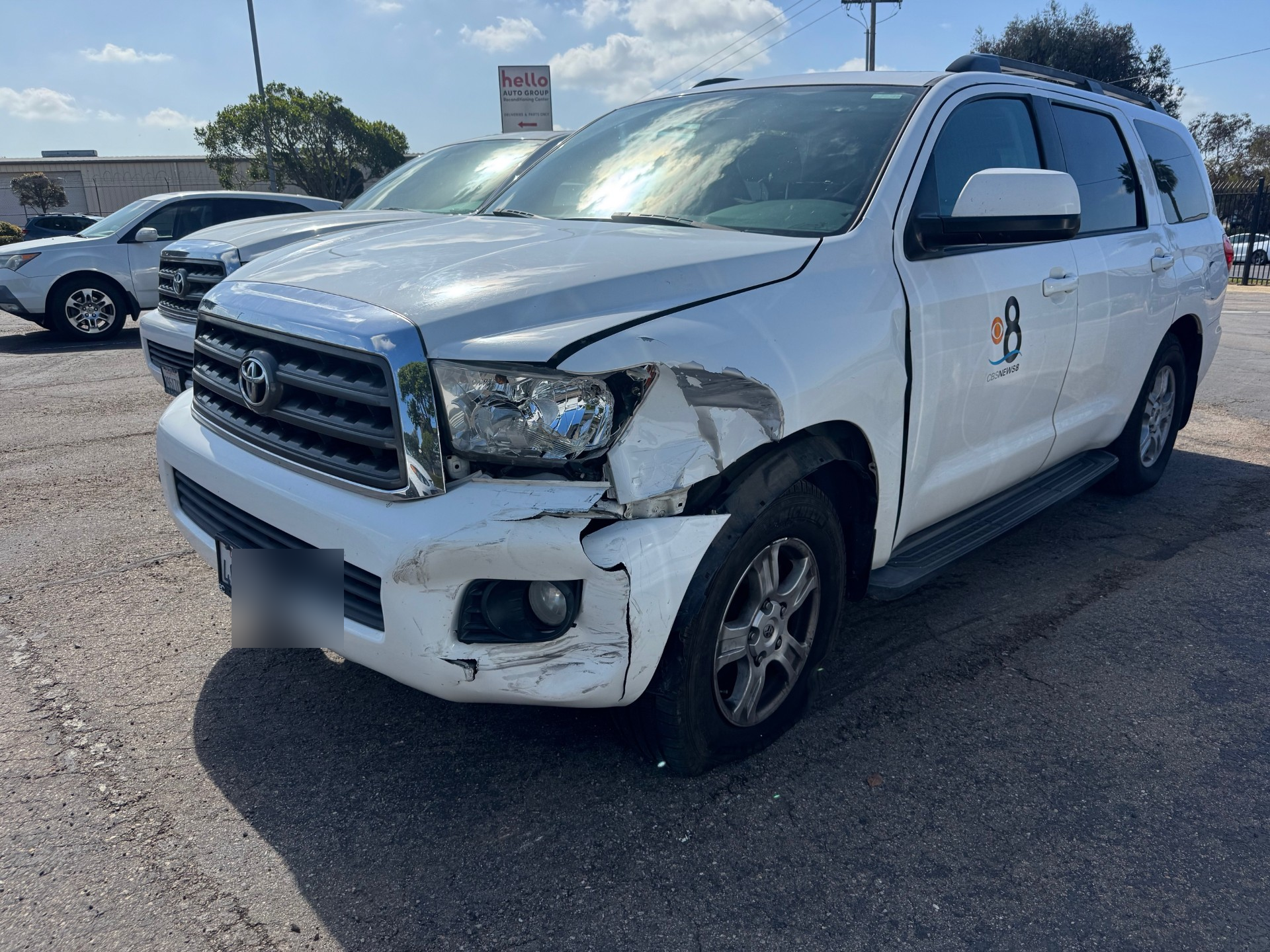 White Toyota SUV in a parking lot with significant damage to the front passenger-side fender and bumper.