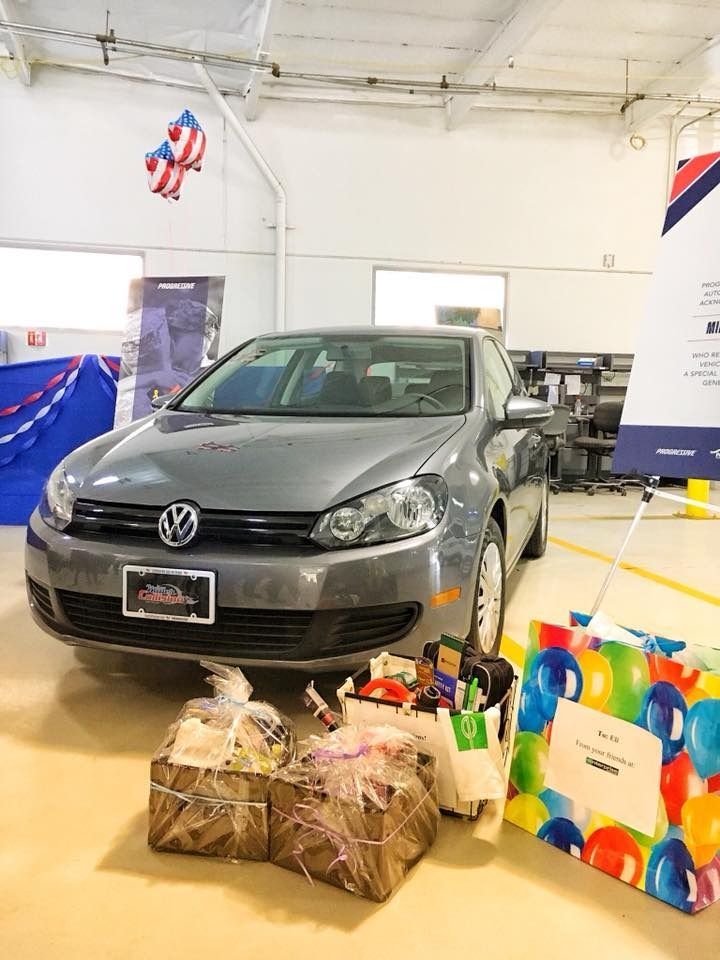 Gray Volkswagen car with gift baskets in an indoor setting.