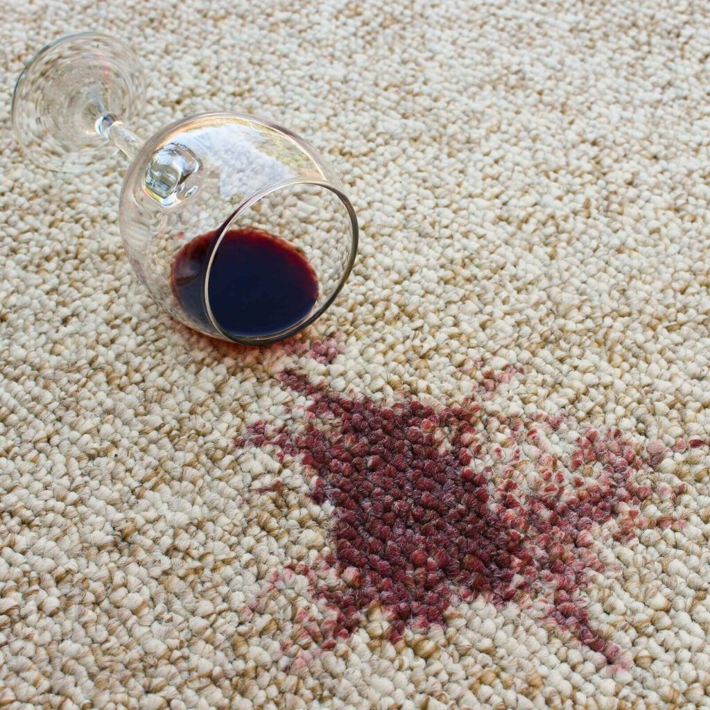 A glass of wine spilled on a carpet.