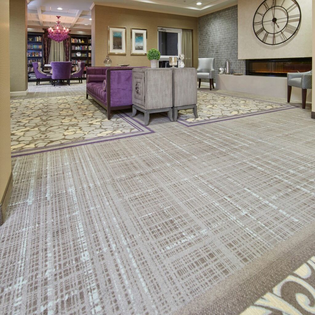 A living room with purple furniture and a clock on the wall