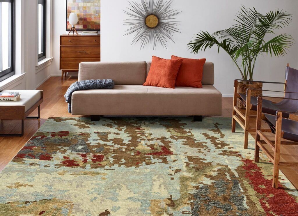 A living room with a couch and a rug on the floor.
