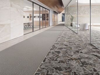 A long hallway with a carpeted floor and a glass wall.