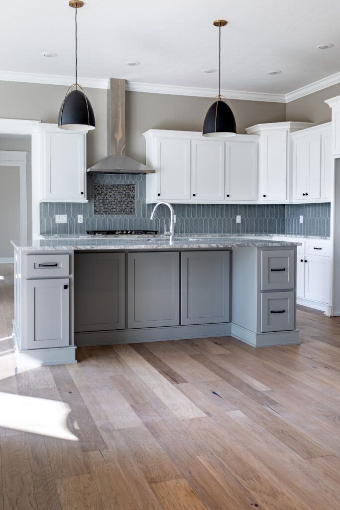 An empty kitchen with white cabinets and a large island.