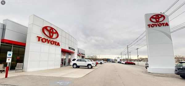 A Toyota dealership with cars parked in front of it.