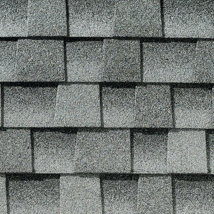 Gray asphalt roof shingles in a close-up pattern.