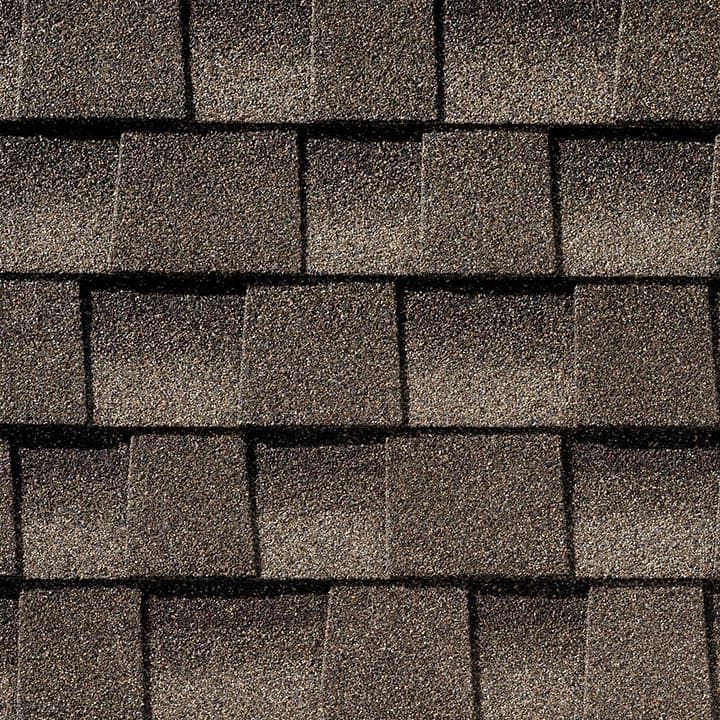 Close-up of asphalt roof shingles in varying shades of brown.