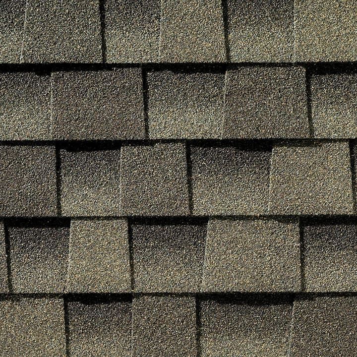 Close-up of overlapping brown asphalt shingles on a roof, creating a textured surface.