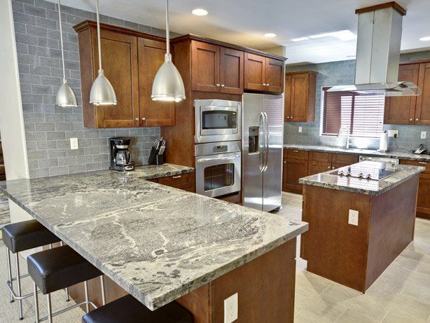 Modern kitchen with granite countertops, stainless steel appliances, and dark wood cabinets.