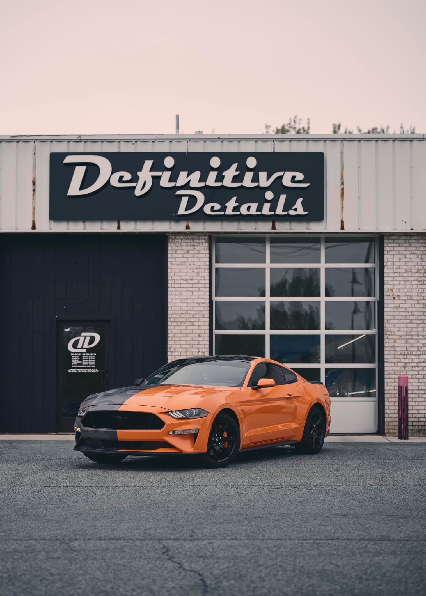 Orange and black Mustang in front of 