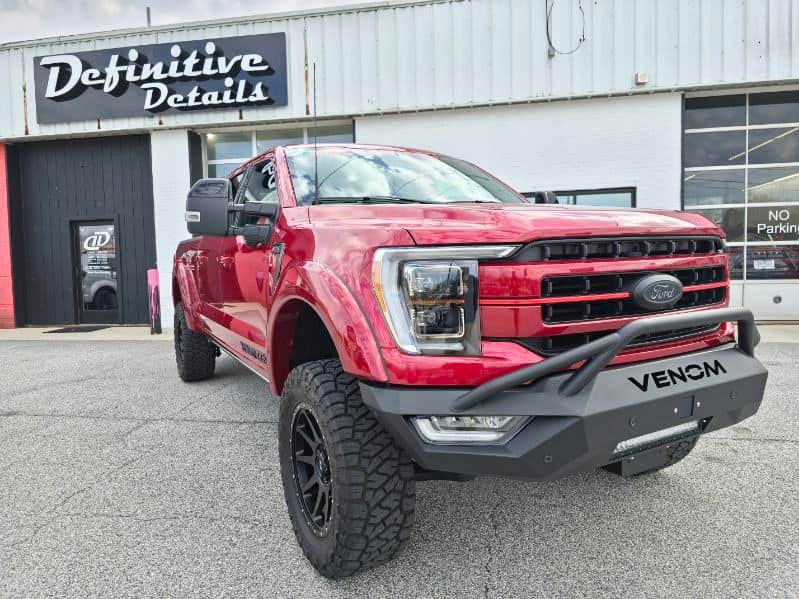 Red Ford truck with black Venom bumper parked outside 