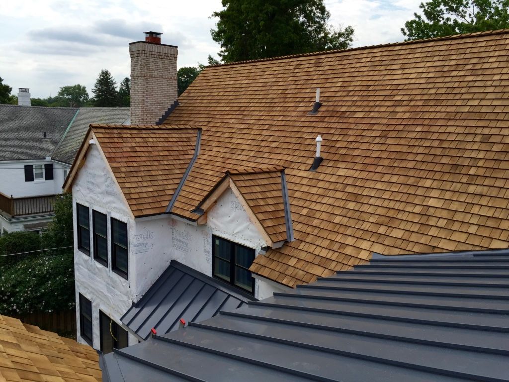 House with tan shingled roof and gray metal roof, viewed from above