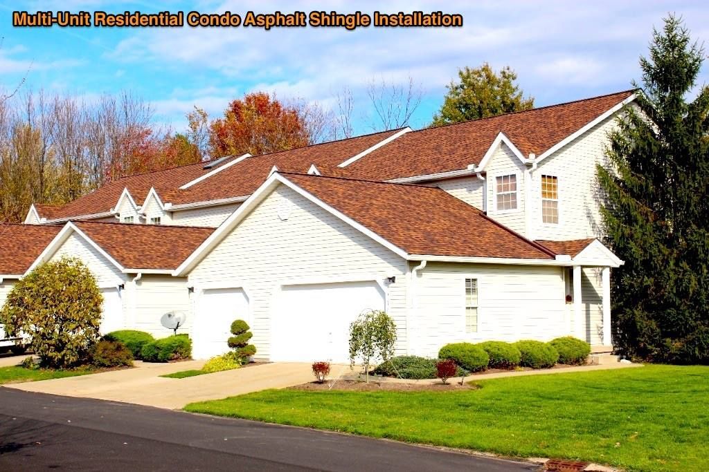 Row of white suburban houses with red roofs and manicured lawns on a sunny day
