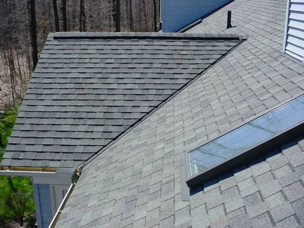 House roof with gray shingles and a dormer, viewed from above