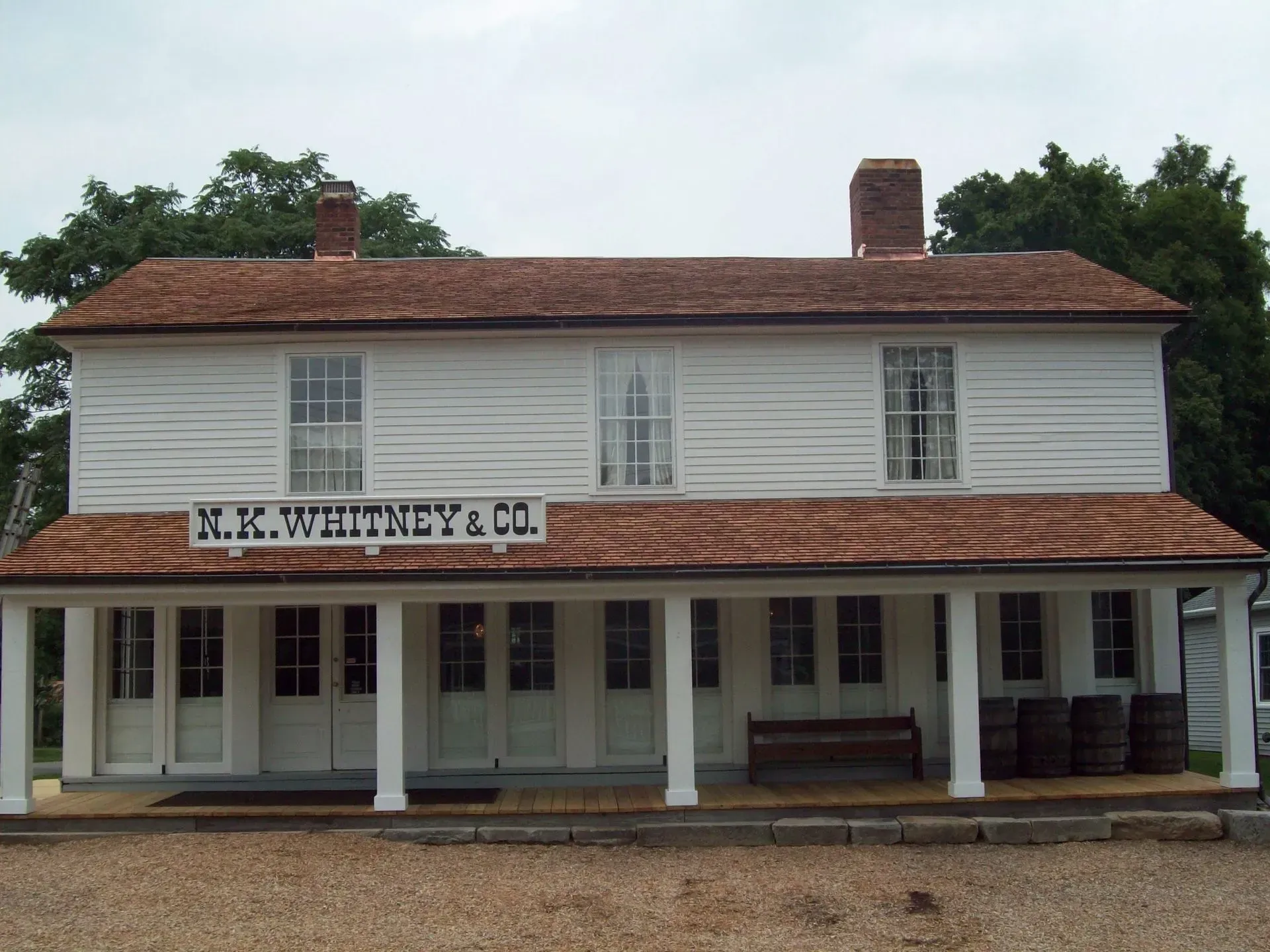 Historic white wooden storefront with red roof and sign reading “R.K. HICKEY & CO.”