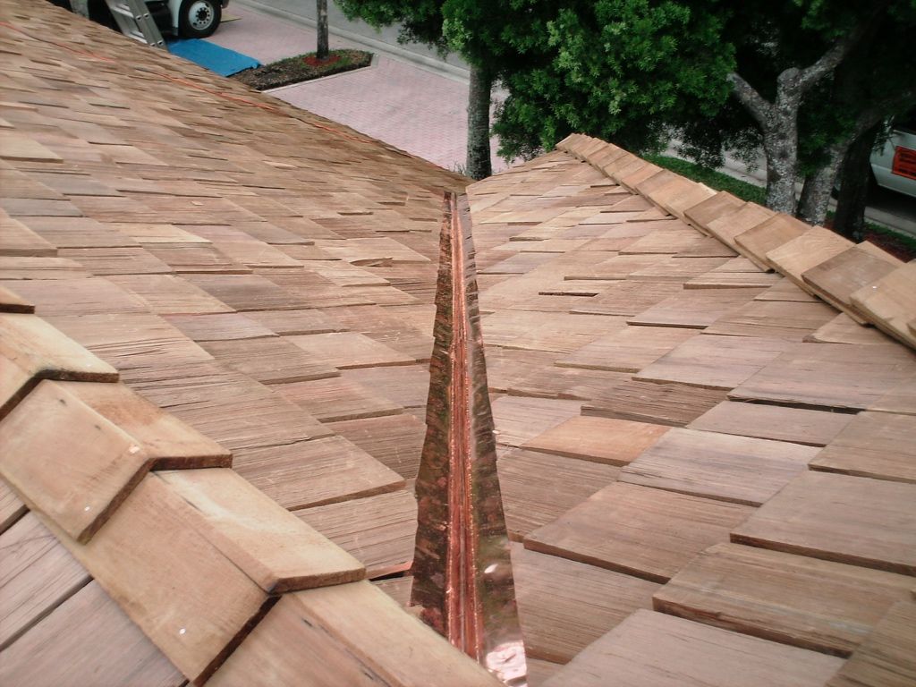 Red-tiled roof with a narrow open valley and trees in the background
