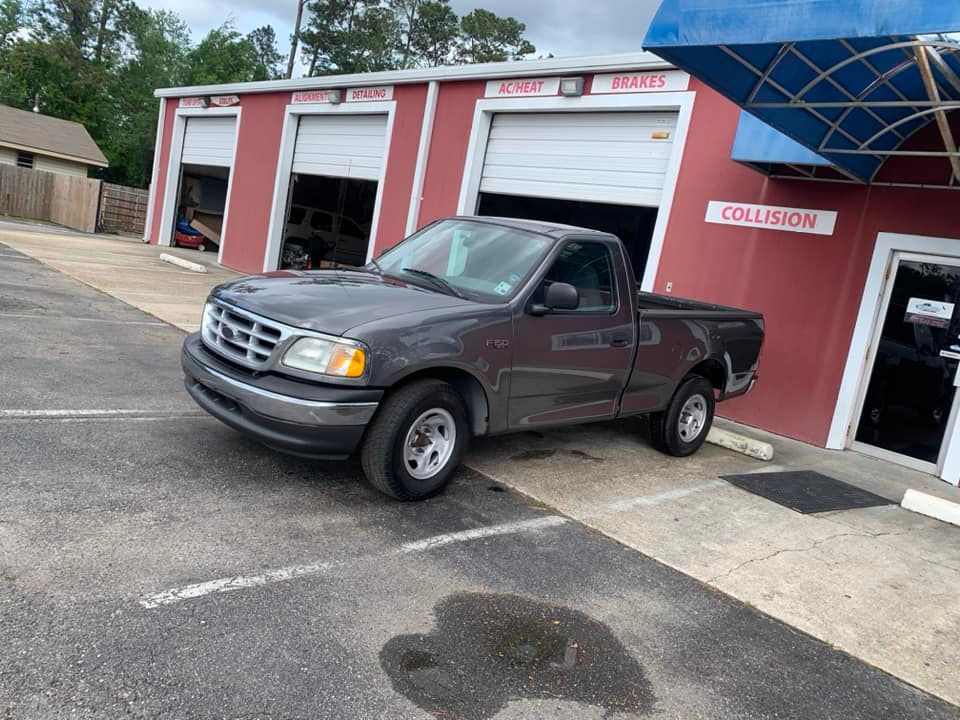 a gray pickup truck is parked in front of a red building .