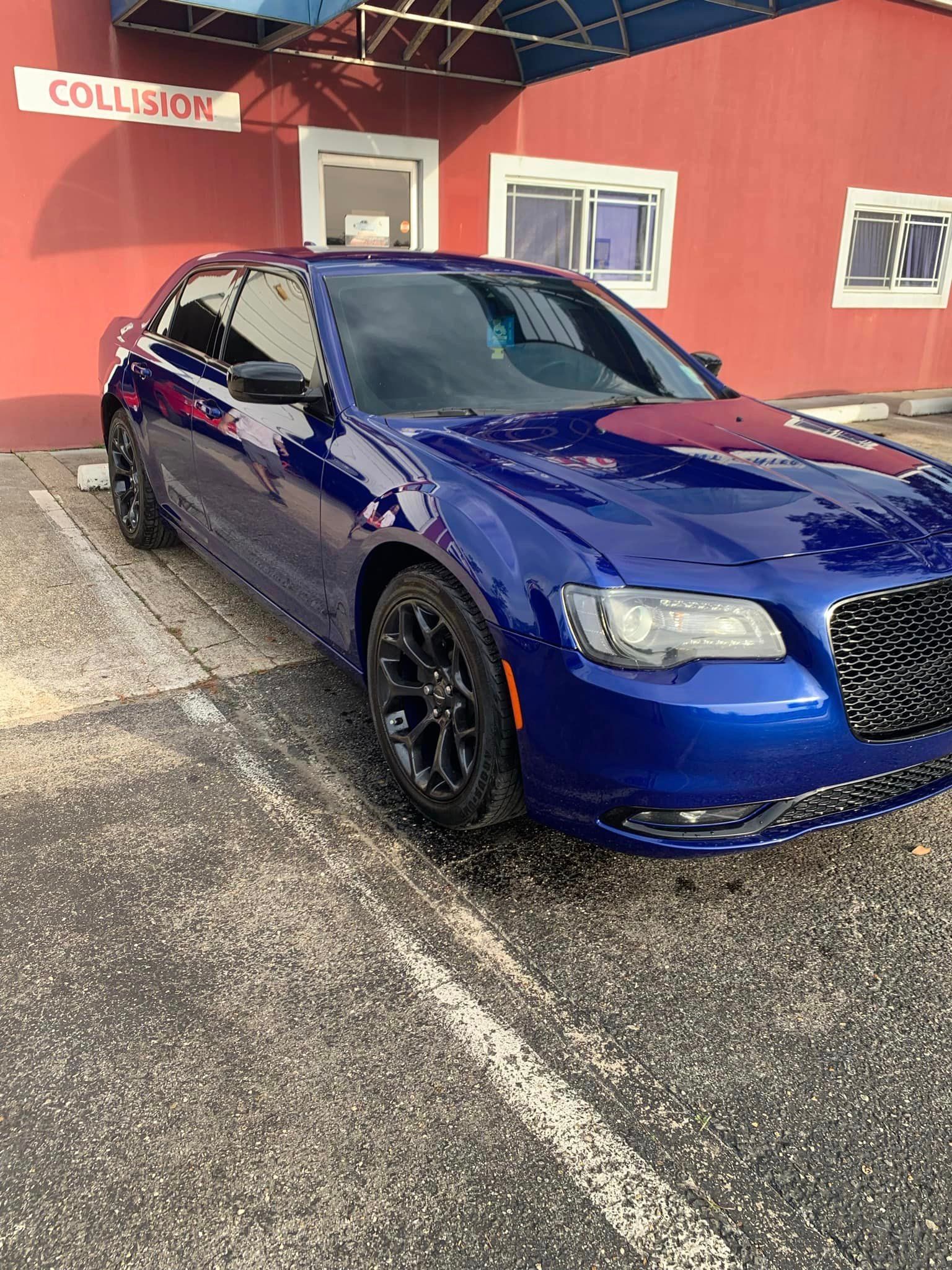 a blue car is parked in front of a red building .