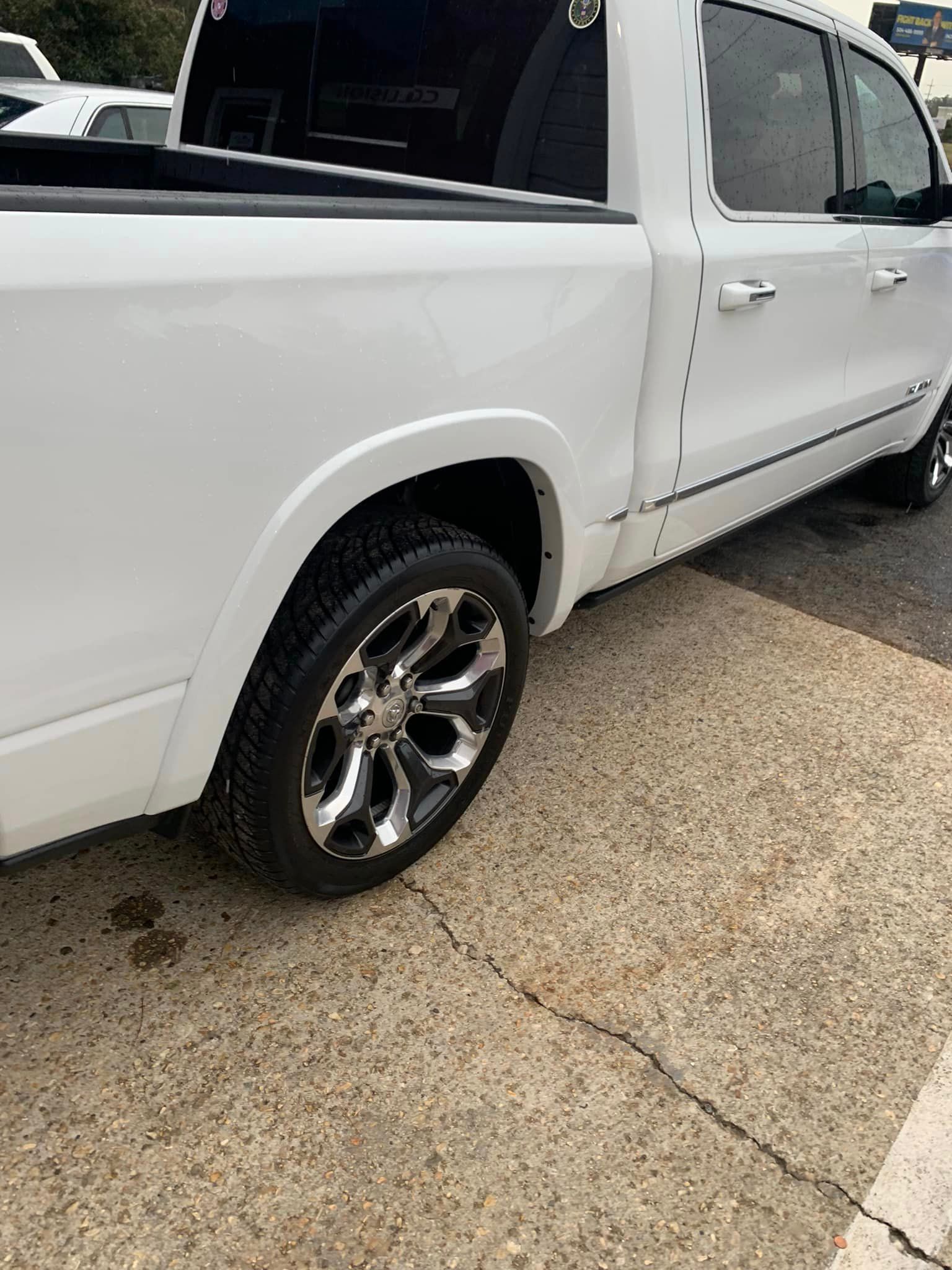a white truck is parked on the side of the road .