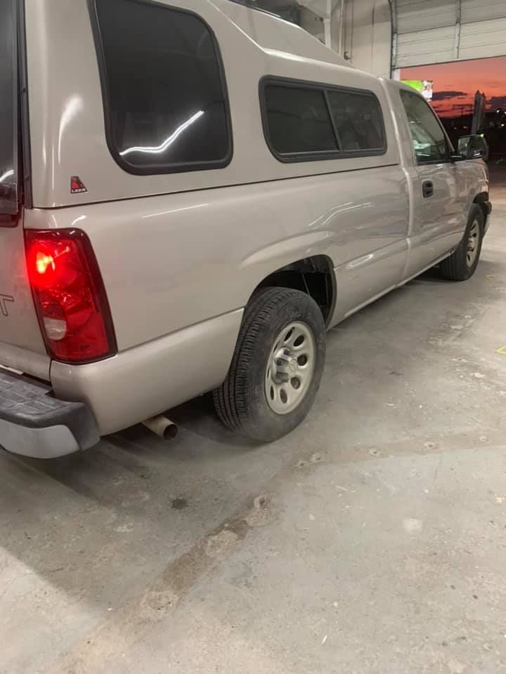 a white truck with a canopy is parked in a garage .