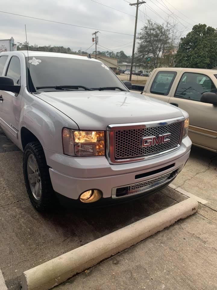 a white gmc truck is parked in a parking lot .
