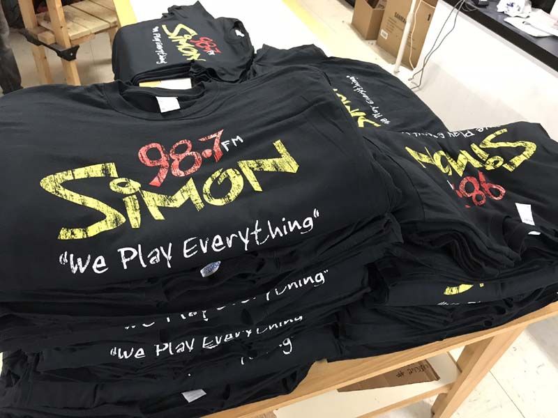 A stack of black t-shirts with the words we play everything on them