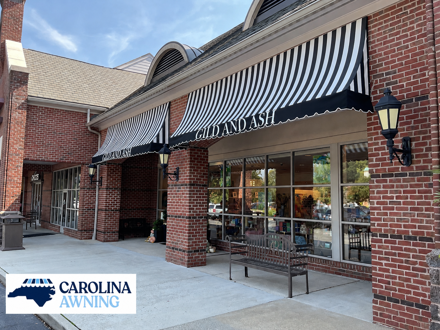Storefront with striped awning and large windows in a brick shopping center corridor