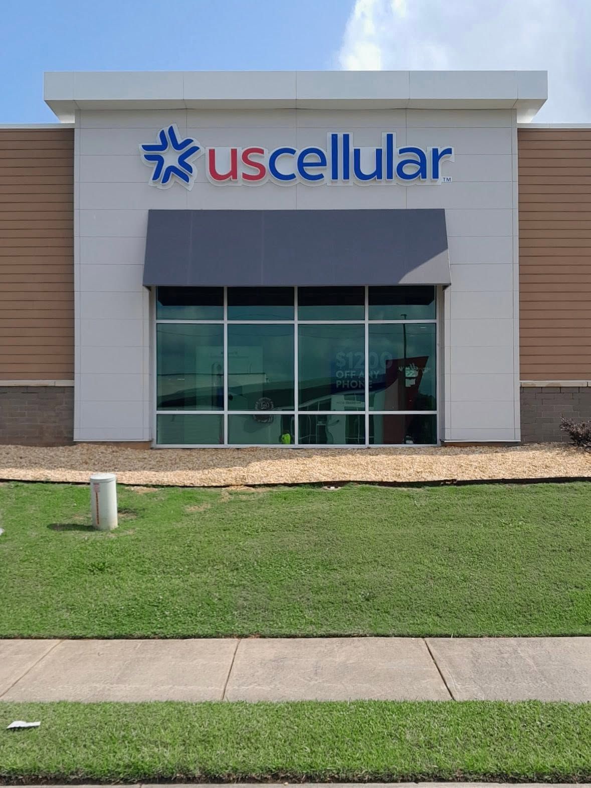 UScellular storefront with glass windows, gray facade, and green grass in front