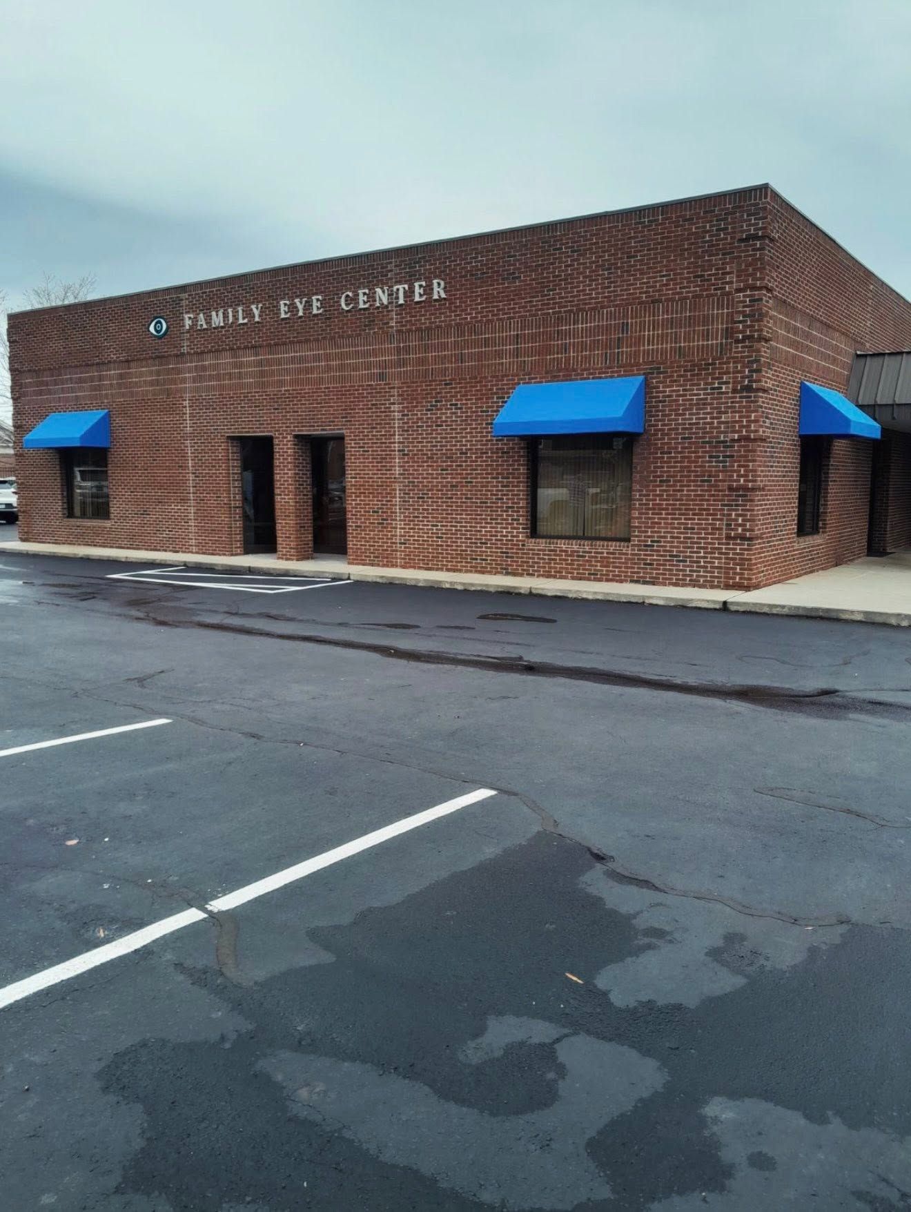 Brick storefront with blue awnings on a cloudy street corner, labeled “Town Center.”