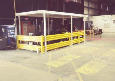 Yellow-guarded industrial machine in a large warehouse interior