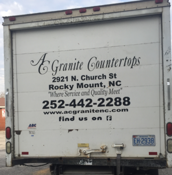 Box truck with A Granite Countertops ad and contact info parked outdoors
