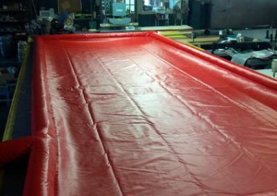 Large red industrial sheet being processed on a factory machine