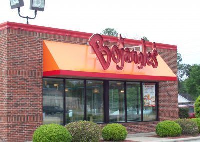 Dog N Joggles storefront with orange awning and glass windows on a brick building