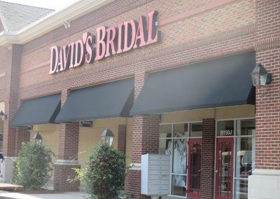 David's Bridal storefront with brick facade, black awnings, and glass entrance.