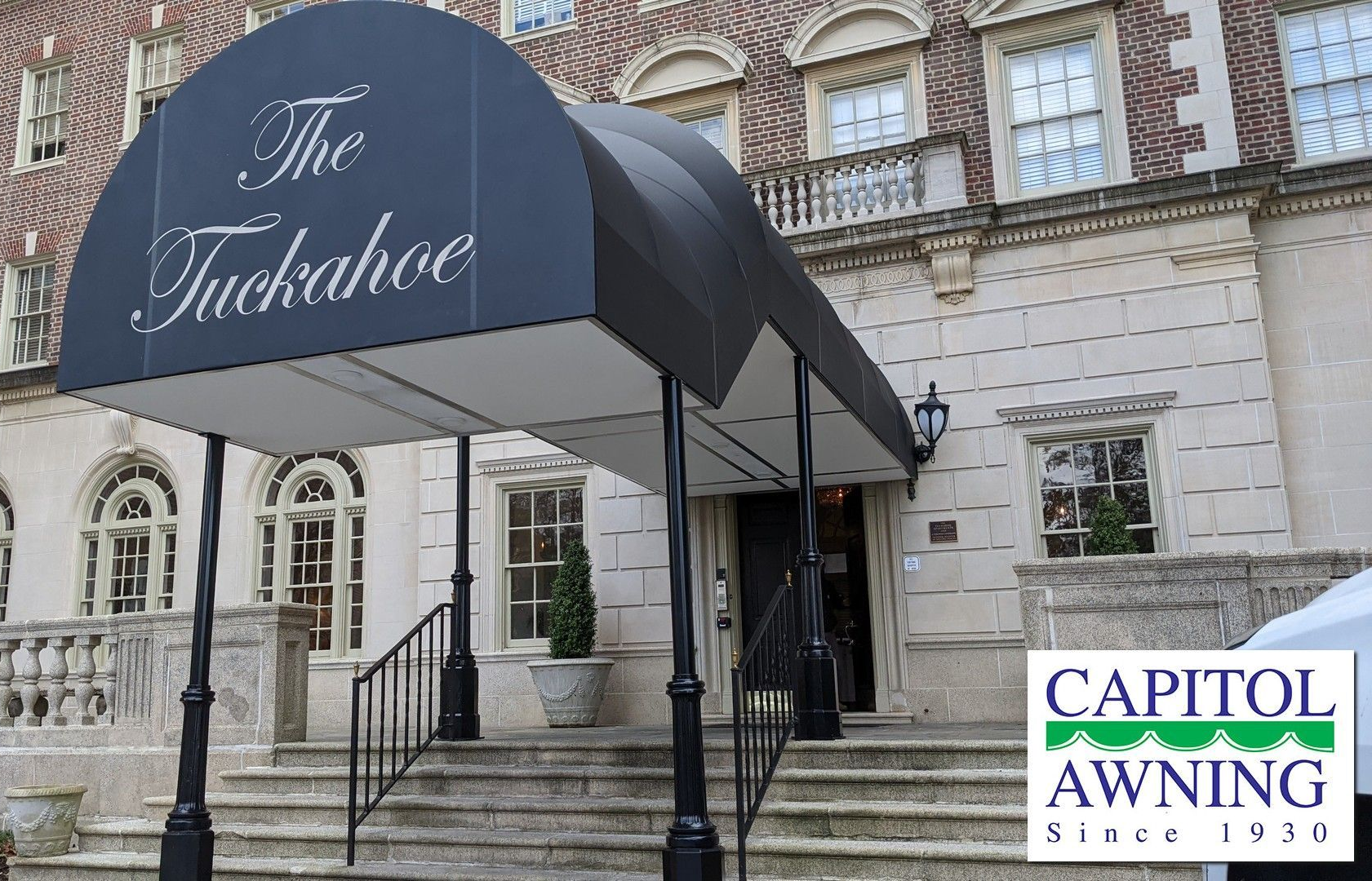 Awning at The Tuxedo entrance on a stone building with Capitol Awning logo